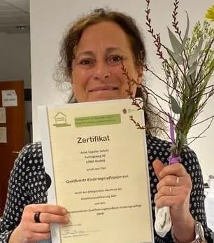 Anke Caputo-Schulz mit ihrem Zertifikat als qualifizierte Kindertagespflegeperson