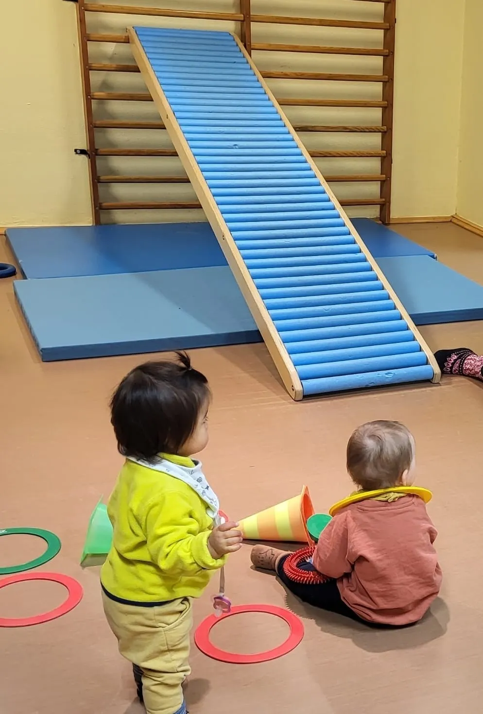 Kinder balancieren gemeinsam über eine Bewegungsrampe beim Turnen