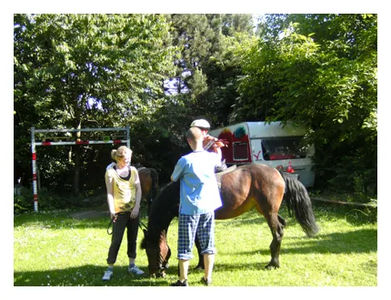Ein Tageskind reitet beim Sommerfest im Garten der Tagesmutter auf einem Pferd