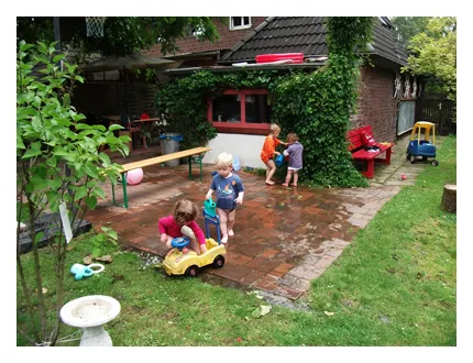 Die Kinder matschen im Garten mit Wasser